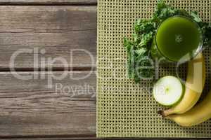 Fresh kale juice in glass with fruits on table
