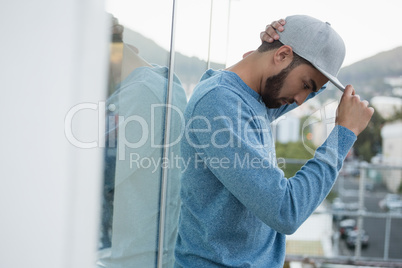 Man posing in cap against glass