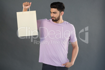 Handsome man looking at shopping bag Handsome man looking at shopping bag