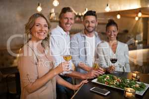 Portrait of happy friends having drinks and meal