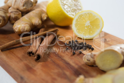 Close-up of lemon and various spices on wooden serving board