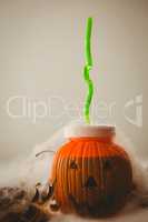 Drink in jack o lantern container against white background