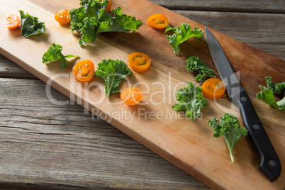 High angle view of kale and tomato slices on cutting board
