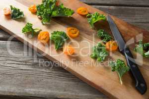 High angle view of kale and tomato slices on cutting board