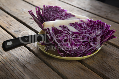 Sliced red cabbage in plate on wooden table