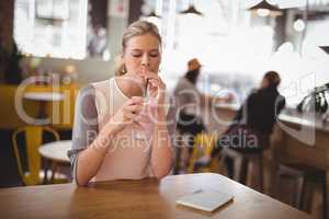 Young beautiful woman drinking milkshake at coffee shop