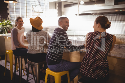 Cheerful young friends sitting table counter