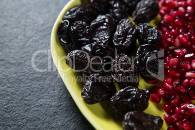 Close-up of dates fruits with pomegranate seeds in plate