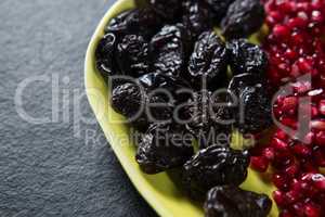 Close-up of dates fruits with pomegranate seeds in plate