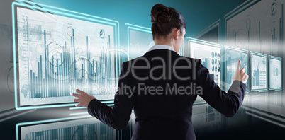 Composite image of rear view of businesswoman using imaginative digital screen