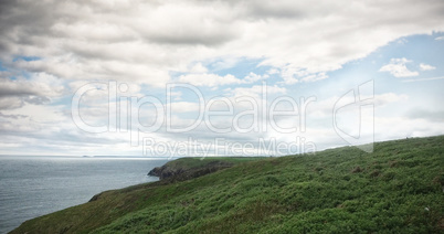 Scenic view of hill by sea