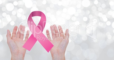 Open hands with pink ribbon for breast cancer awareness