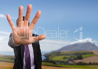 Businessman in nature with hand signal to stop