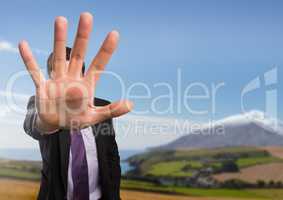 Businessman in nature with hand signal to stop