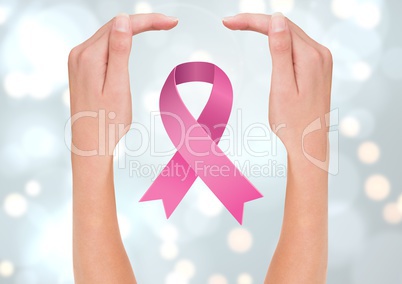 Open hands with pink ribbon for breast cancer awareness