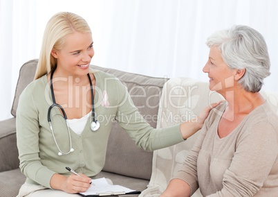 Doctor woman with breast cancer awareness ribbon and patient