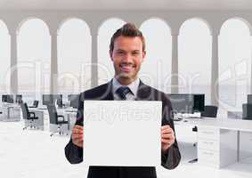 Happy business man holding blank card in office