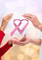 Open hands together with pink ribbon for breast cancer awareness