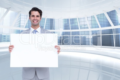 Happy business man holding blank card in office