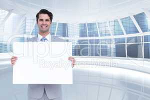 Happy business man holding blank card in office