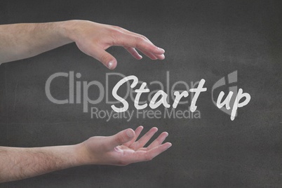 Hands interacting with start-up business text against grey background