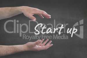 Hands interacting with start-up business text against grey background