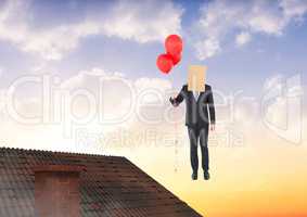 Businessman floating with balloons and bag on head over roof