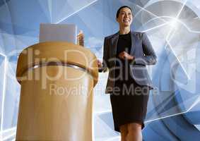 Businesswoman on podium speaking at conference with futuristic shapes