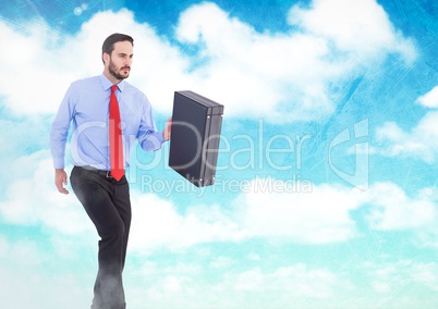 Businessman holding briefcase in sky clouds