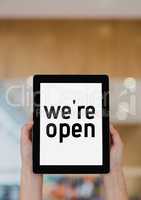 Business woman holding a tablet with we are open text