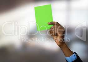 Hand holding green card in bright room