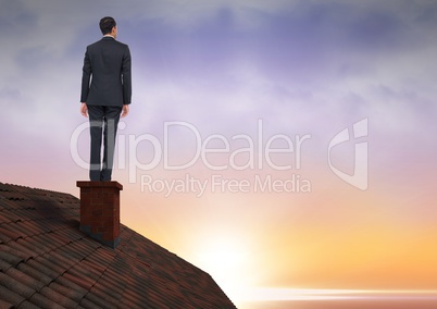 Businessman on roof chimney with sunset