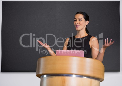 Businesswoman on podium speaking at conference with board
