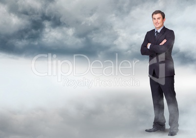 Businessman folding arms in cloudy sky