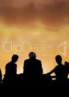 Business people at a meeting silhouette against sunset or sunrise