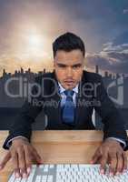 Businessman on keyboard in front of city skyline
