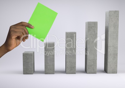 Hand holding green card over incremented bar chart