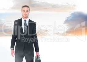 Businessman holding briefcase in twilight sky