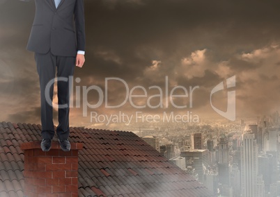 Businessman standing on Roof with chimney and cloudy city
