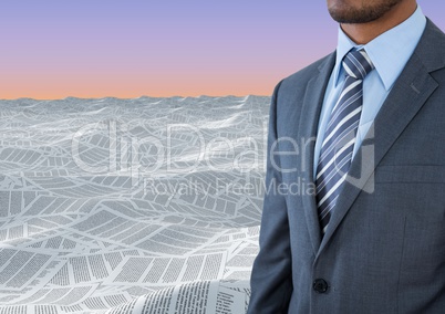 Businessman in sea of documents under sky