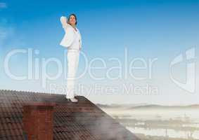 Businesswoman standing on Roof with chimney and landscape