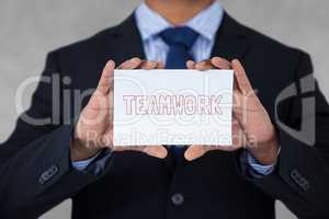 Business man holding a card with teamwork text