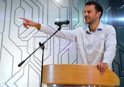 Businessman on podium speaking at conference with technology background