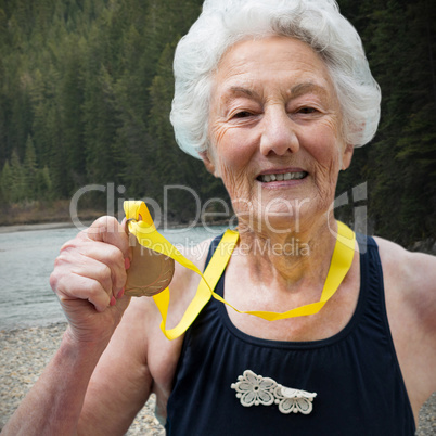 Composite image of portrait of female swimmer showing medal