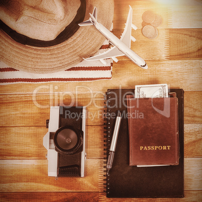 Overhead view of diary with currency by digital tablet and luggage