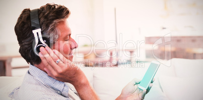 Man listening to music on headphones in living room