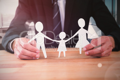 Composite image of mid section of businessman holding paper family