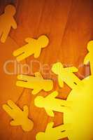 Blue and yellow paper cut out figures on wooden table