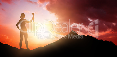 Composite image of woman posing with trophy