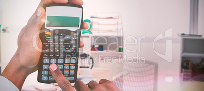 Composite image of hands of businessman using calculator